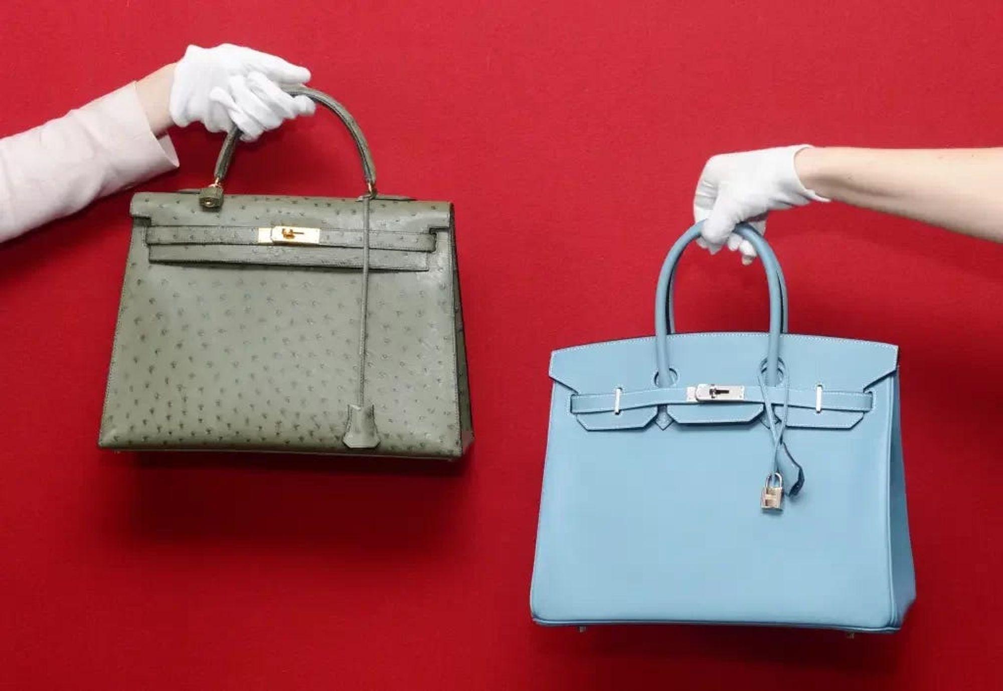 Fundo vermelho com duas mãos segurando bolsas de luxo