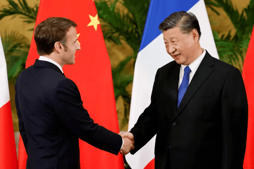 Foto de Xi Jinping cumprimentando Emmanuel Macron